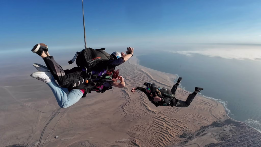 People tandem skydiving over the desert in Namibia.